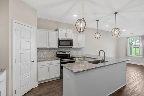 a kitchen with sink cabinets and chandelier