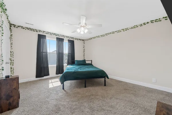 a bedroom with furniture and a ceiling fan
