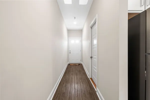 a view of a hallway with wooden floor and staircase