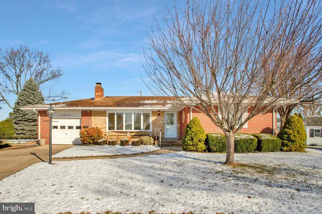 a front view of a house with a yard and potted plants