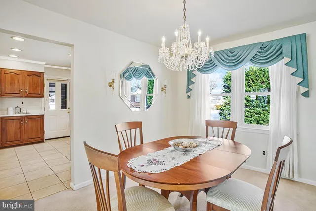 a view of a dining room with furniture a chandelier and wooden floor