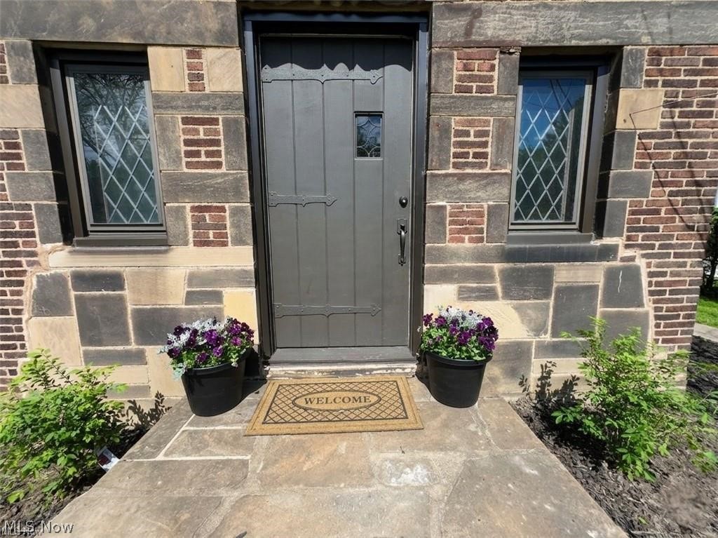 3145 Huntington Road Shaker Heights, OH 44120 - Photo 3 of 28 Stone facade with brick accents and a detailed entry door featuring iron hardware