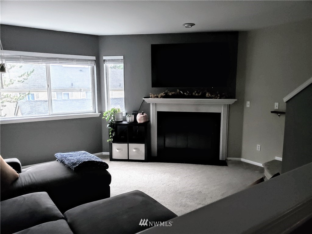 833 Southwest Sunset Boulevard, Unit B7 Renton, WA 98057 - Photo 15 of 33 a living room with furniture a flat screen tv and a fireplace