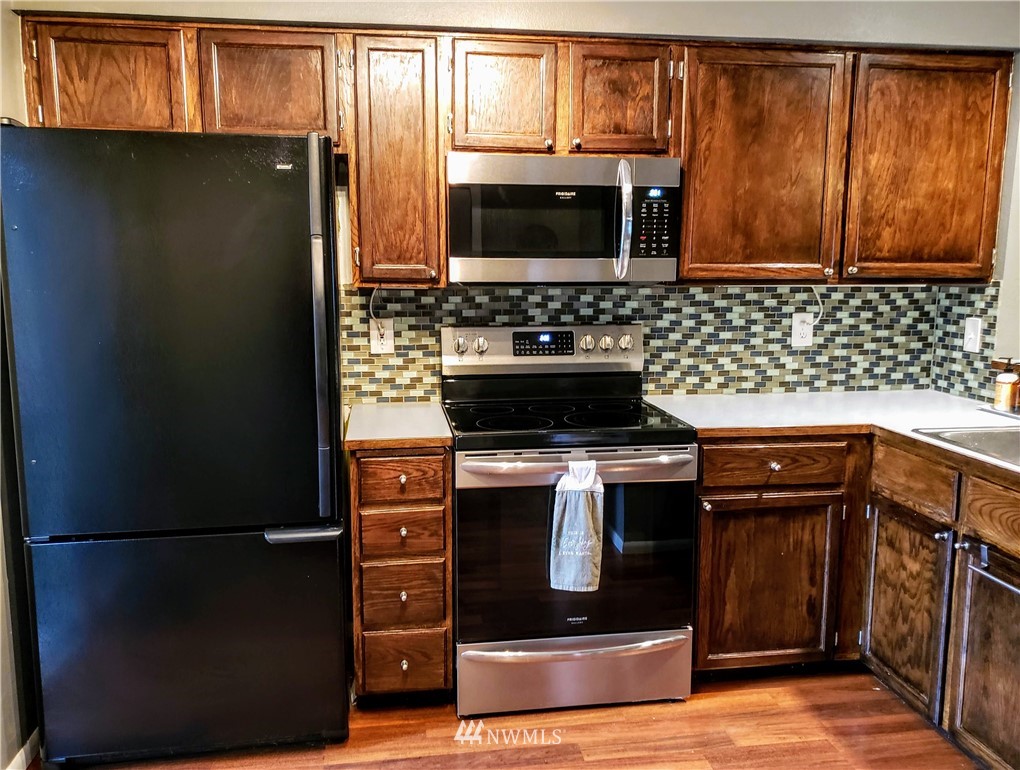 833 Southwest Sunset Boulevard, Unit B7 Renton, WA 98057 - Photo 5 of 33 a kitchen with stainless steel appliances granite countertop a refrigerator and a stove