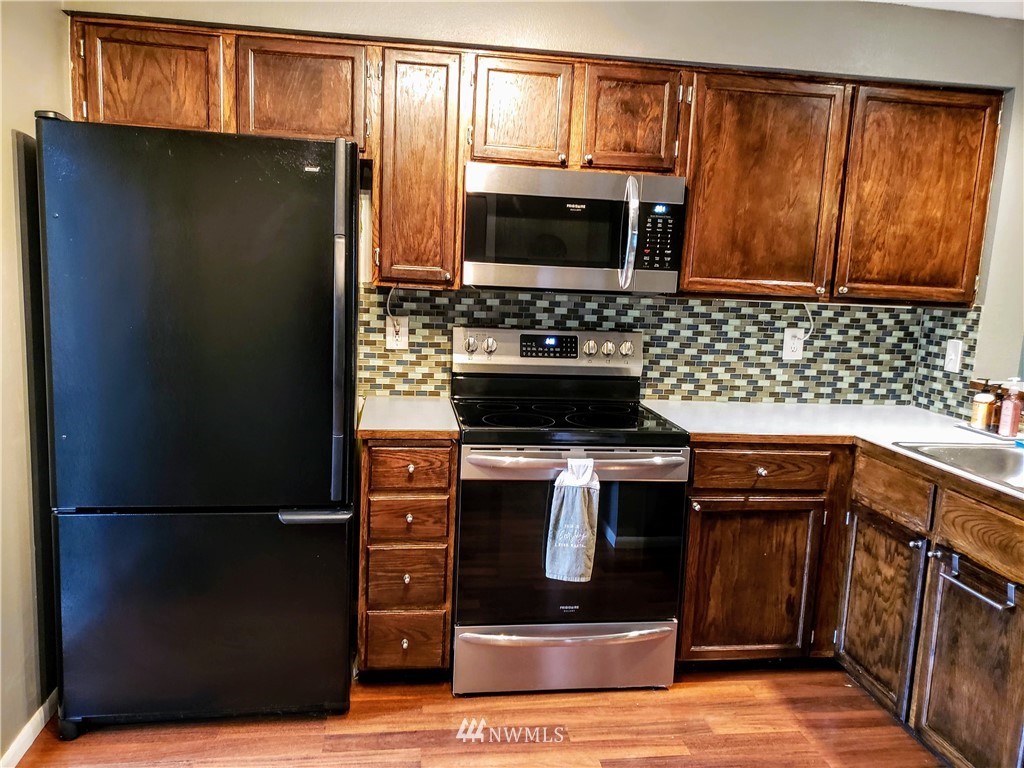 833 Southwest Sunset Boulevard, Unit B7 Renton, WA 98057 - Photo 6 of 33 a kitchen with stainless steel appliances granite countertop a refrigerator stove and sink