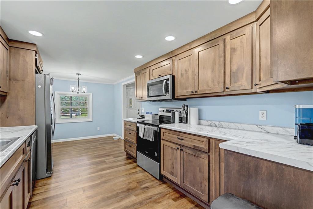 134 Church Road Thomaston, GA 30286 - Photo 10 of 33 a kitchen with stainless steel appliances granite countertop a stove a sink dishwasher and a refrigerator with wooden cabinets