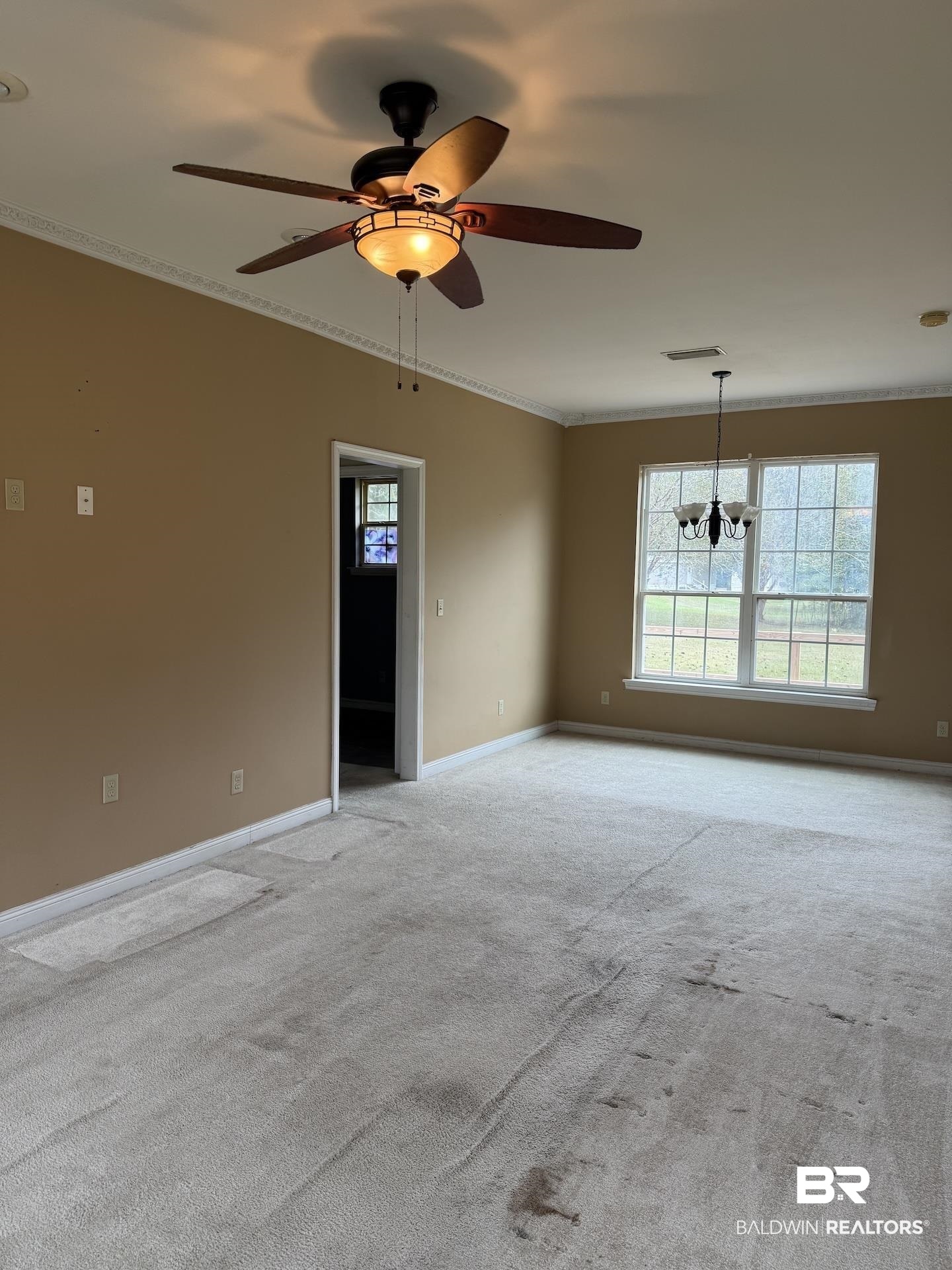 99 Cemetery Street Uriah, AL 36480 - Photo 3 of 13 Empty room with suspended lighting, light colored carpet, crown molding, a ceiling fan, and healthy amount of natural light