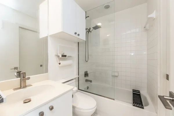 a bathroom with a sink a toilet and shower