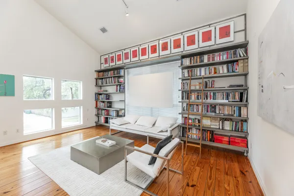 a living room with furniture a bookshelf and a book shelf