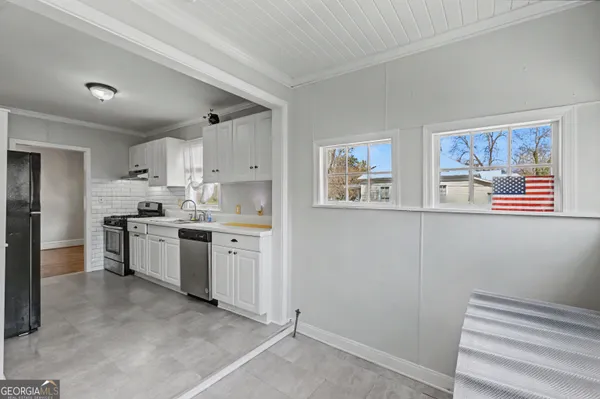 a kitchen with white cabinets and white appliances