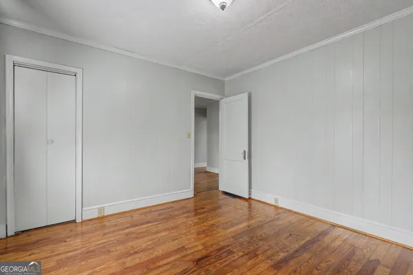 a view of an empty room with wooden floor