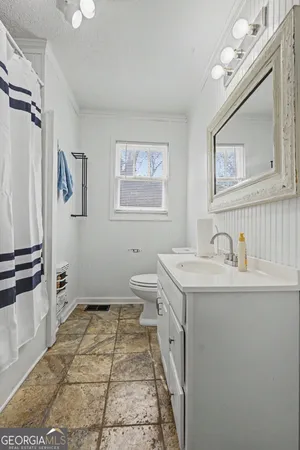 a bathroom with a sink a toilet and mirror