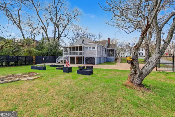 a view of a house with a big yard and large trees
