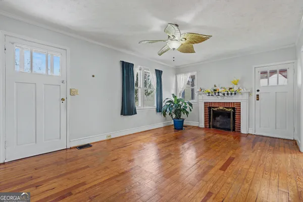 a view of a room with wooden floor fireplace and chandelier