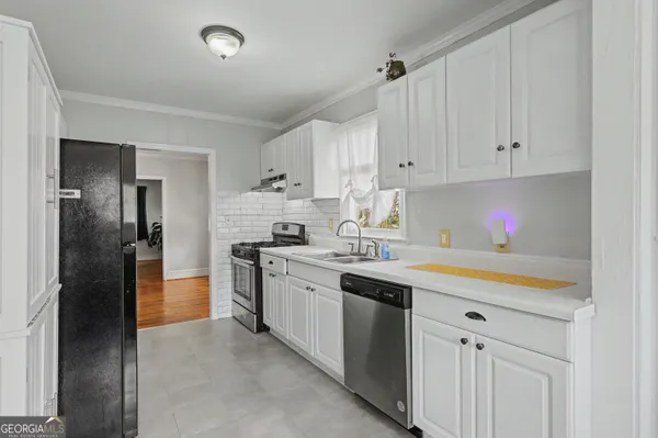 a kitchen with stainless steel appliances granite countertop a sink and a refrigerator