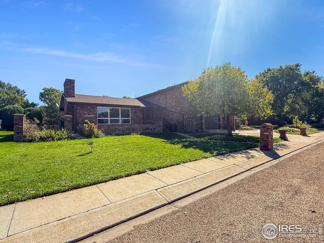 a view of a house with a yard and large tree