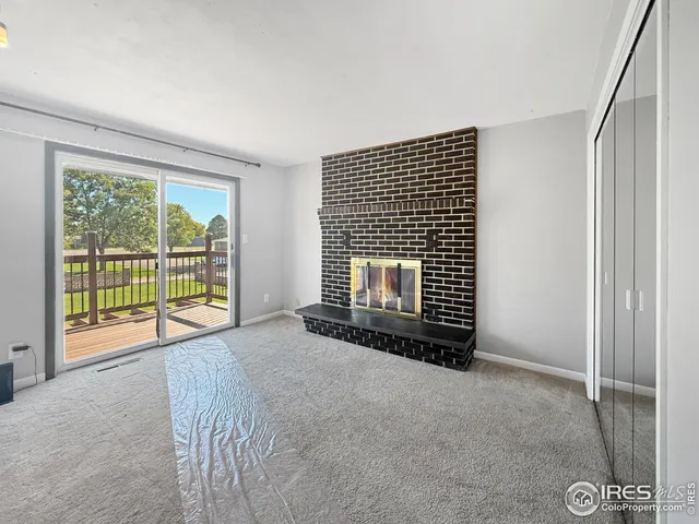 a view of an empty room with a fireplace and a window