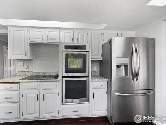 a kitchen with white cabinets and stainless steel appliances