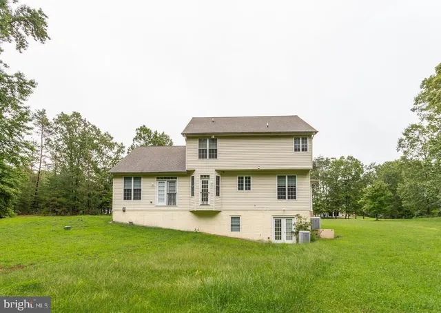 a view of a white house with a big yard and potted plants
