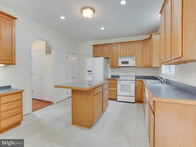 a kitchen with granite countertop a sink stove and cabinets