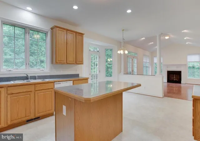 a kitchen with stainless steel appliances granite countertop a sink a stove and a large window