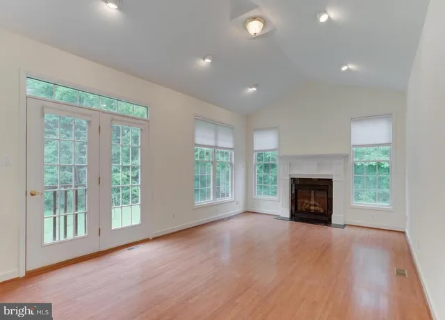 a view of an empty room with a fireplace and a window