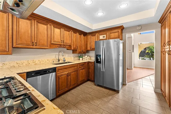a kitchen with stainless steel appliances granite countertop a refrigerator and a sink