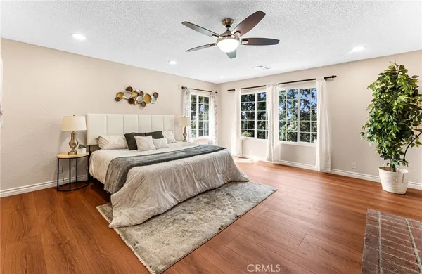 a bedroom with a large bed and a potted plant
