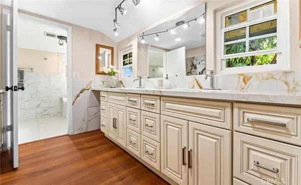 a spacious bathroom with a double vanity sink a mirror and a shower