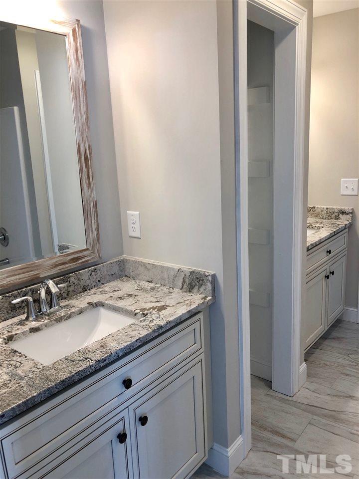 3717 Massey Ridge Court Raleigh, NC 27616 - Photo 20 of 24 a bathroom with a granite countertop sink and a mirror
