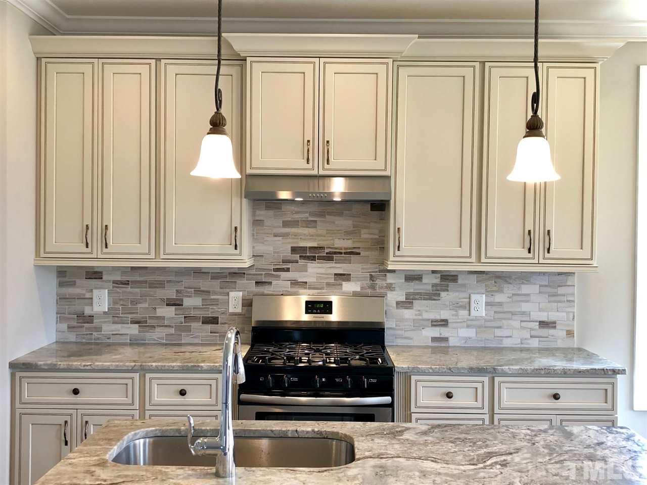 3717 Massey Ridge Court Raleigh, NC 27616 - Photo 7 of 24 a kitchen with granite countertop a stove sink and cabinets