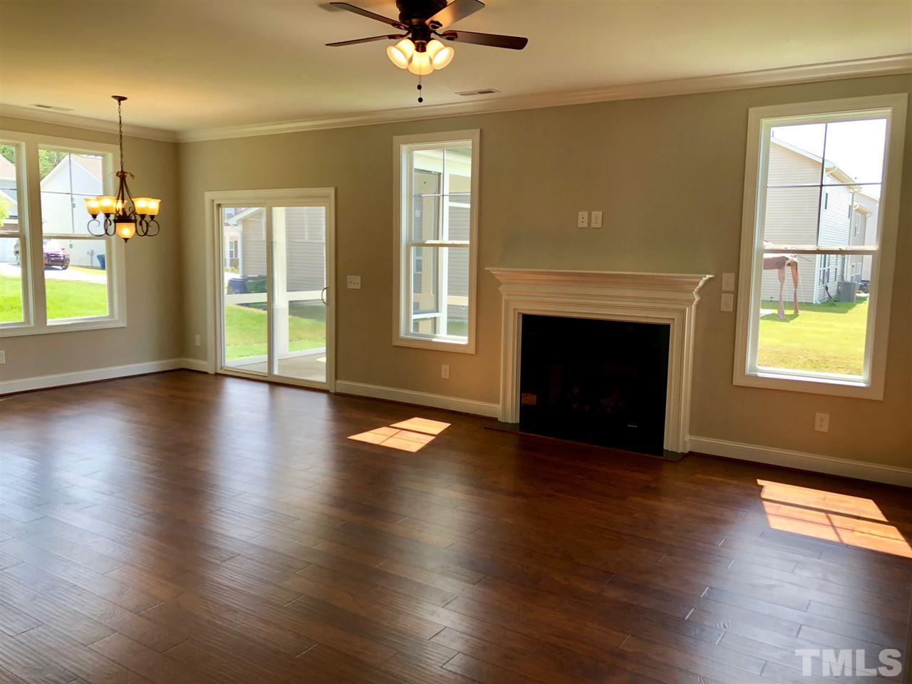 3717 Massey Ridge Court Raleigh, NC 27616 - Photo 10 of 24 an empty room with wooden floor fireplace and windows