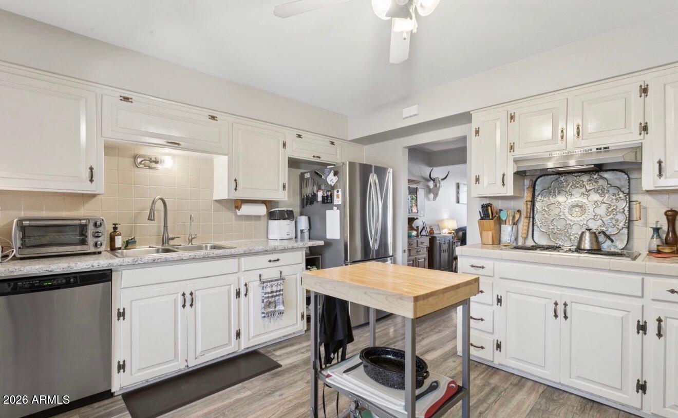 1030 East Bethany Home Road, Unit 6 Phoenix, AZ 85014 - Photo 5 of 15 a kitchen with white cabinets and chairs