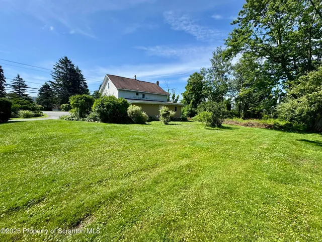 a view of a field with a house in the background