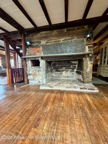 a view of water heater room with wooden floor