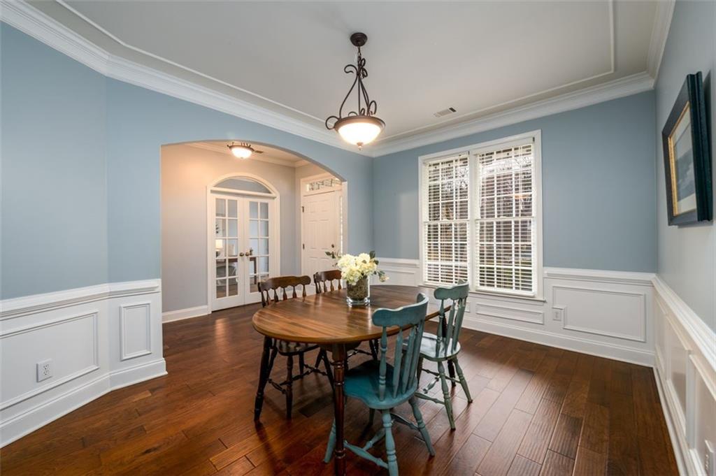 284 Graymist Path Southwest Loganville, GA 30052 - Photo 9 of 45 a dining room with wooden floor a chandelier a wooden table and chairs