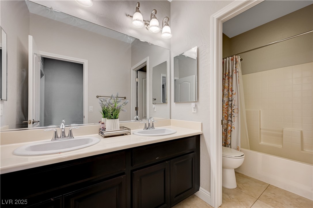7311 Spring Flower Avenue Las Vegas, NV 89117 - Photo 45 of 48 Bathroom with double vanity, shower / bath combo with shower curtain, and tile patterned floors