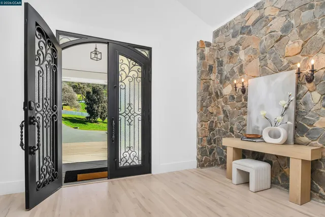 a living room with furniture a fireplace and a floor to ceiling window