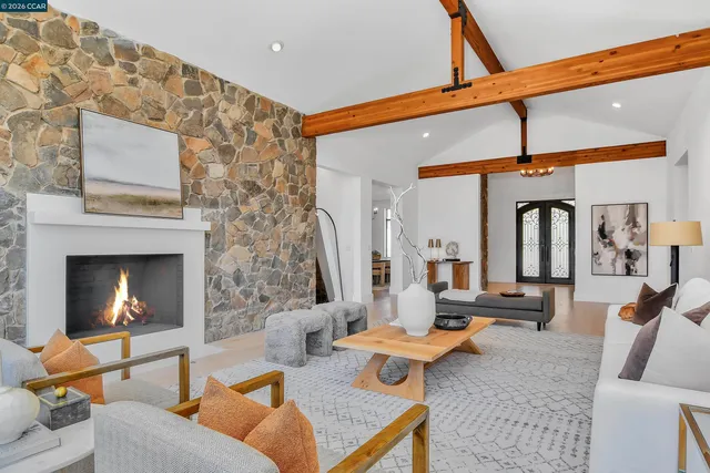 a living room with fireplace furniture and a large window