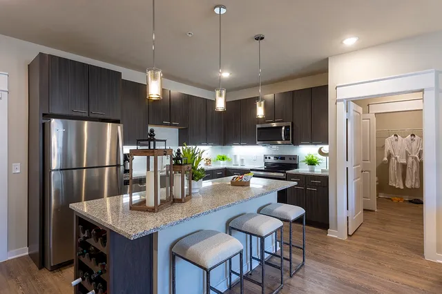 a kitchen with refrigerator a refrigerator and chairs