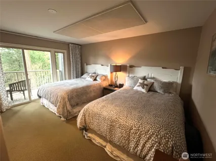 a bedroom with two beds and a large window