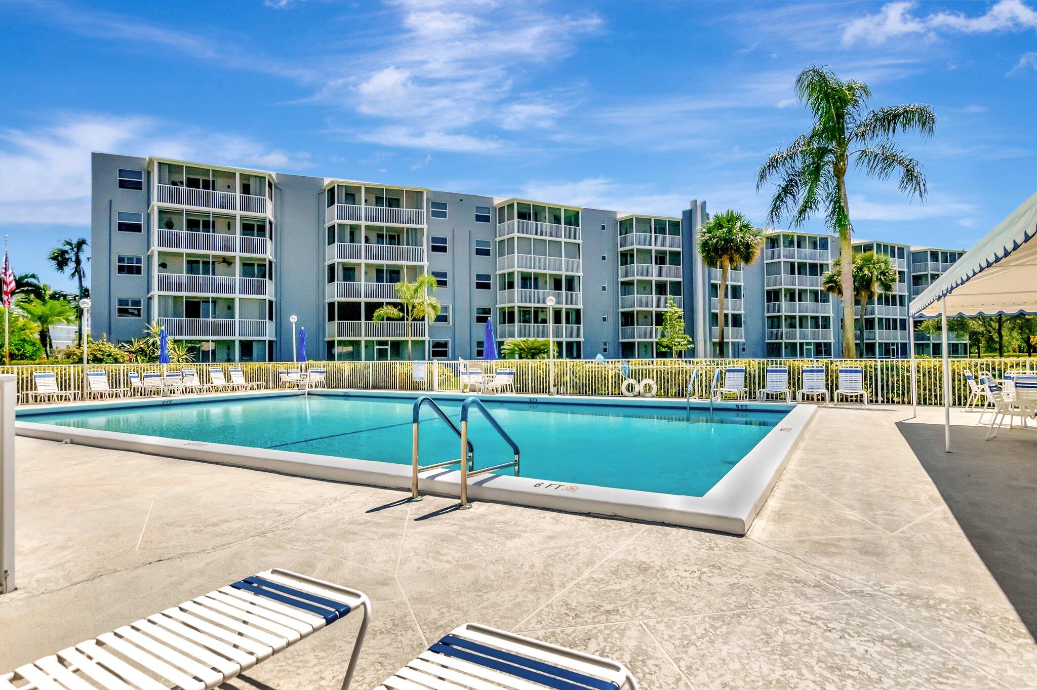 6699 Northwest 2nd Avenue, Unit 410 Boca Raton, FL 33487 - Photo 1 of 29 a view of a swimming pool with a lounge chairs