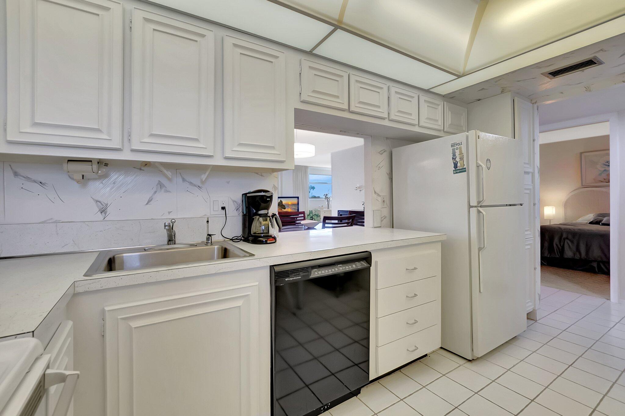 6699 Northwest 2nd Avenue, Unit 410 Boca Raton, FL 33487 - Photo 11 of 29 a kitchen with white cabinets and refrigerator