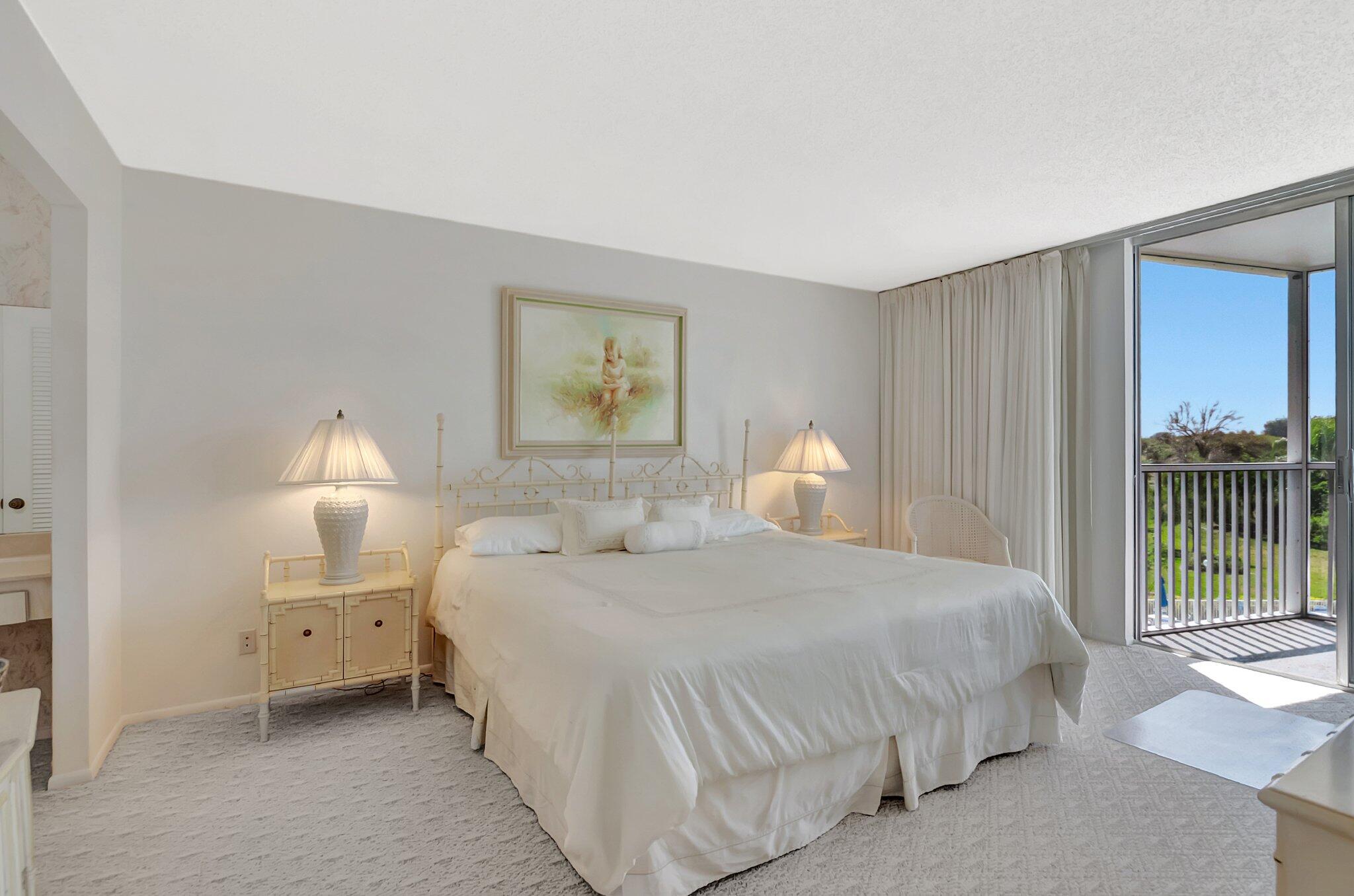 6699 Northwest 2nd Avenue, Unit 410 Boca Raton, FL 33487 - Photo 13 of 29 a bedroom with a bed and a lamp on dresser