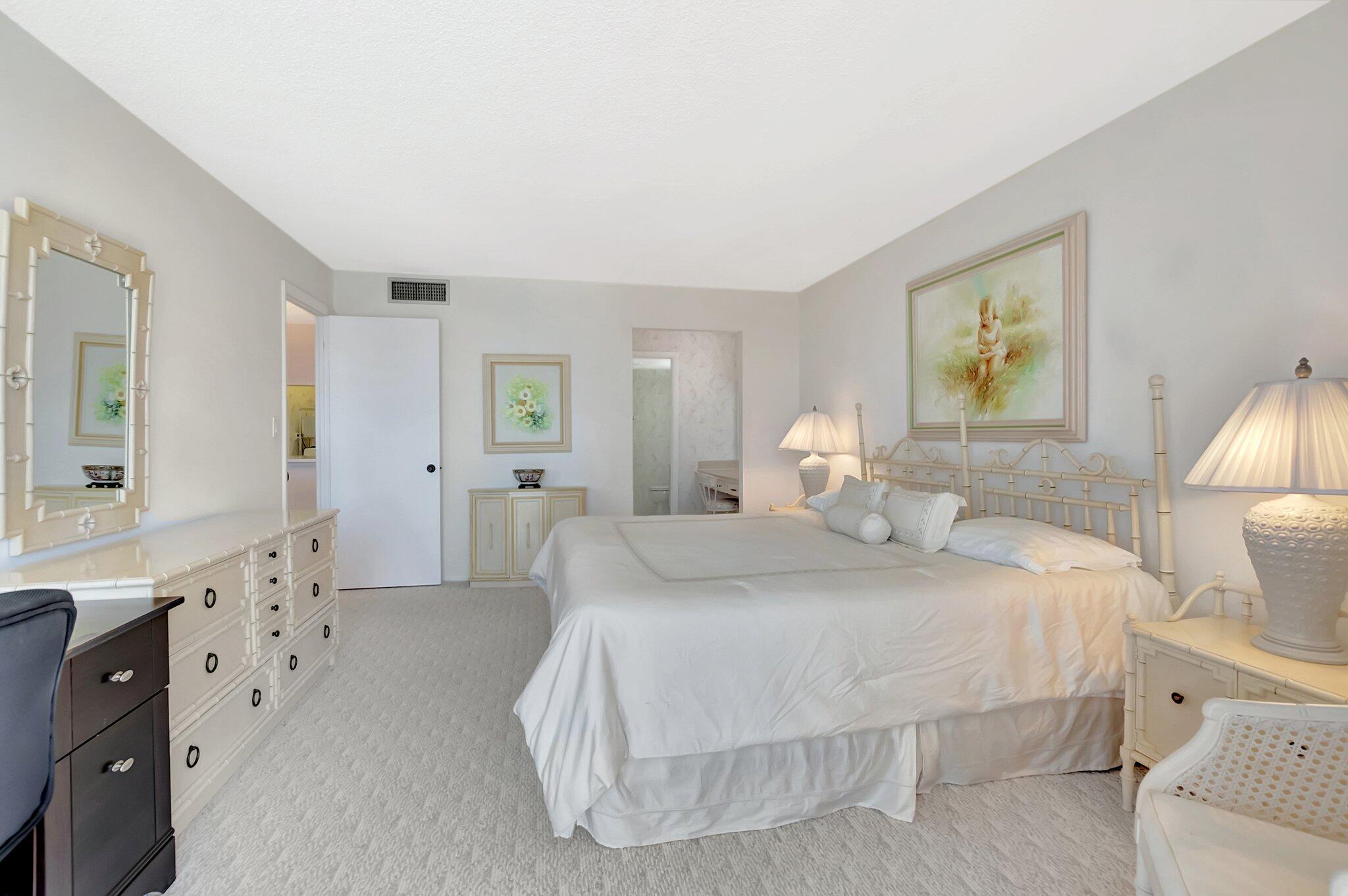 6699 Northwest 2nd Avenue, Unit 410 Boca Raton, FL 33487 - Photo 14 of 29 a bedroom with a bed and a lamp on dresser