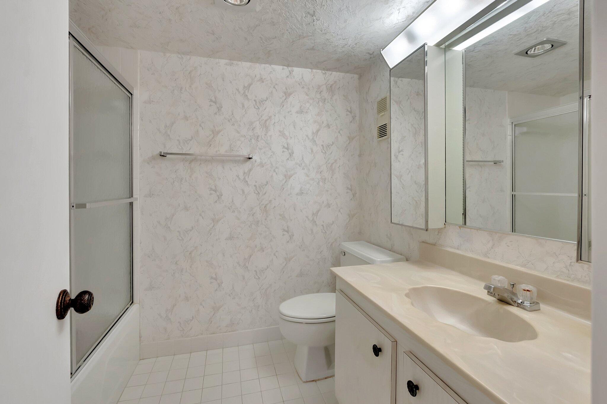 6699 Northwest 2nd Avenue, Unit 410 Boca Raton, FL 33487 - Photo 16 of 29 a bathroom with a granite countertop sink a toilet and shower