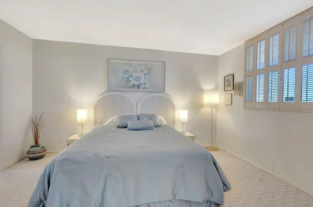 a bedroom with a bed and a painting on the wall