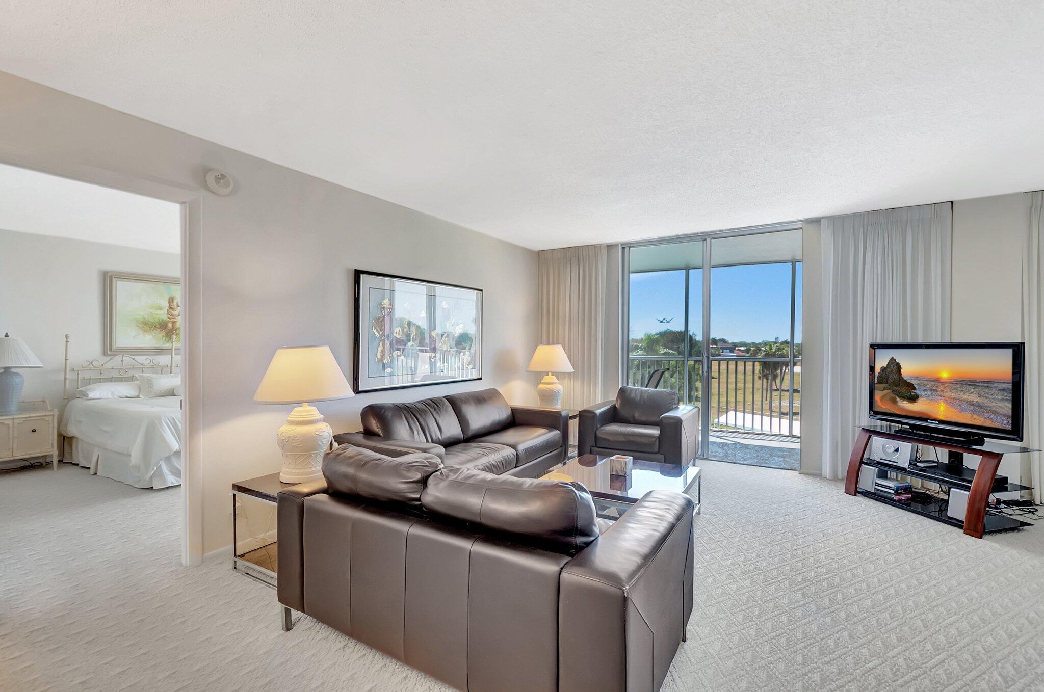 6699 Northwest 2nd Avenue, Unit 410 Boca Raton, FL 33487 - Photo 2 of 29 a living room with furniture and a flat screen tv