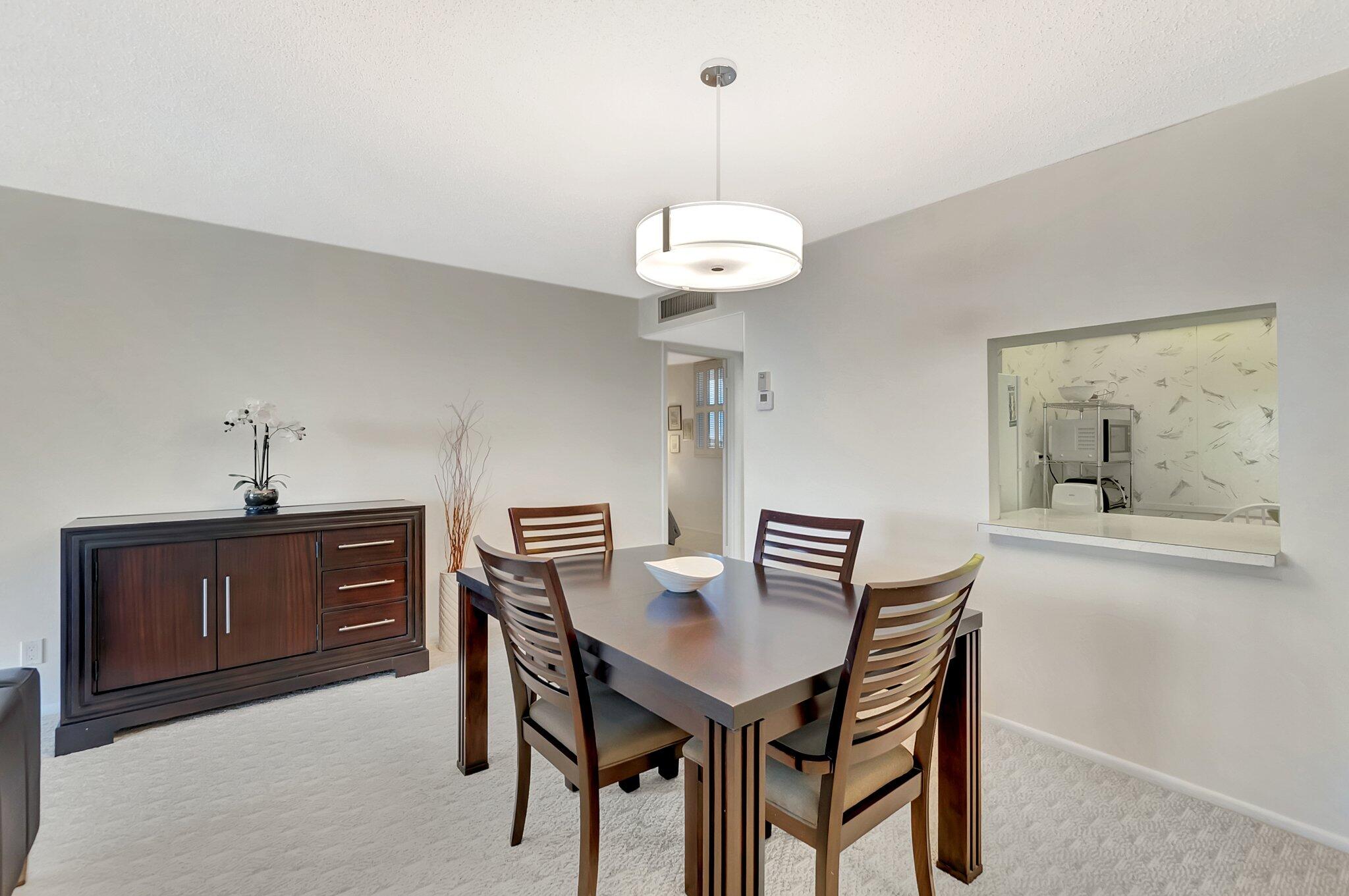 6699 Northwest 2nd Avenue, Unit 410 Boca Raton, FL 33487 - Photo 7 of 29 a view of a dining room furniture and chandelier