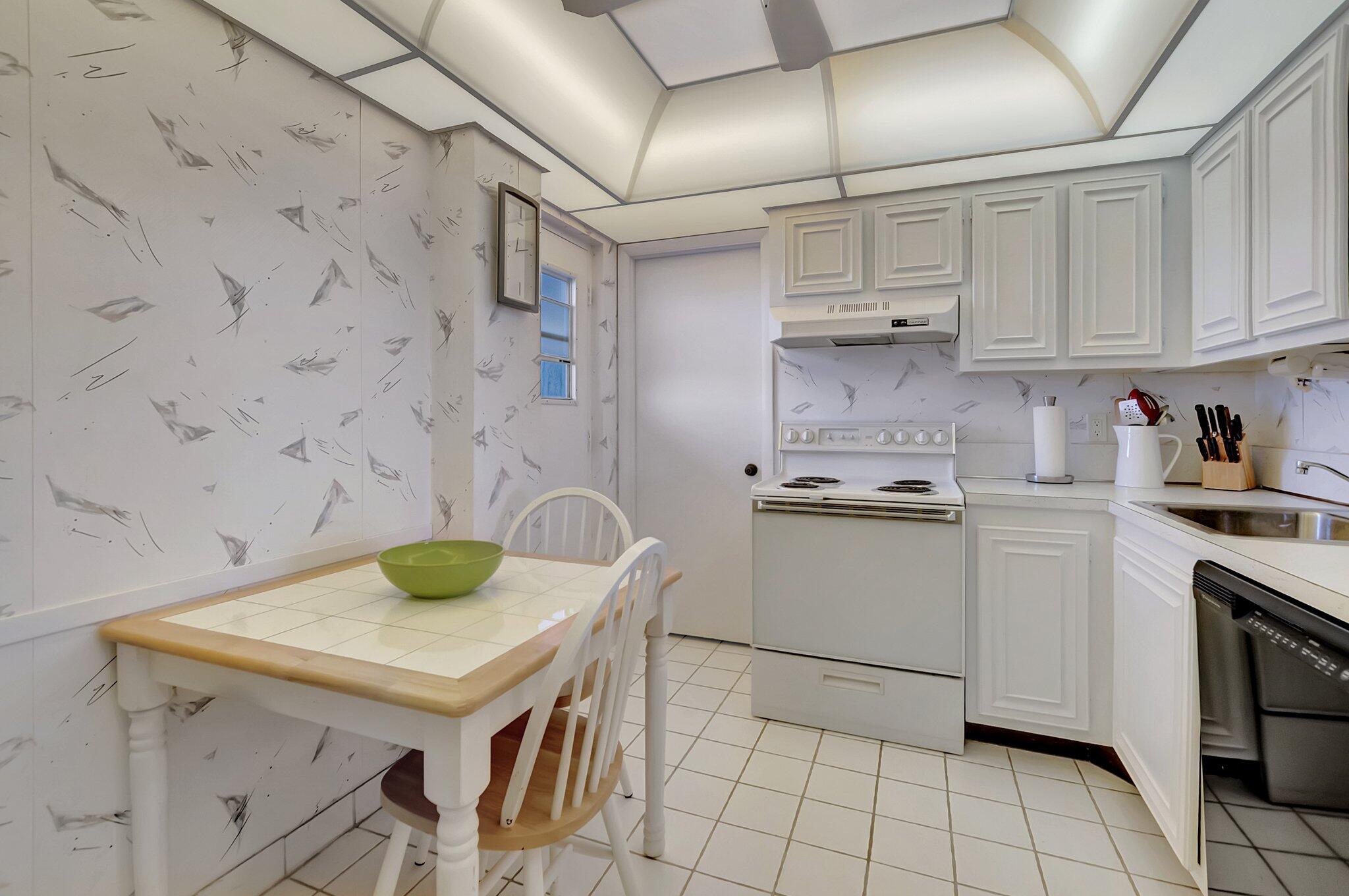6699 Northwest 2nd Avenue, Unit 410 Boca Raton, FL 33487 - Photo 10 of 29 a kitchen with a sink a stove and cabinets